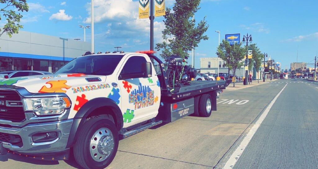 Towing Service Near Me: How to Pick a Tow Company You Can Trust White Skyline Towing Ram 5500 flatbed with puzzle-piece graphics carrying a car on a city street