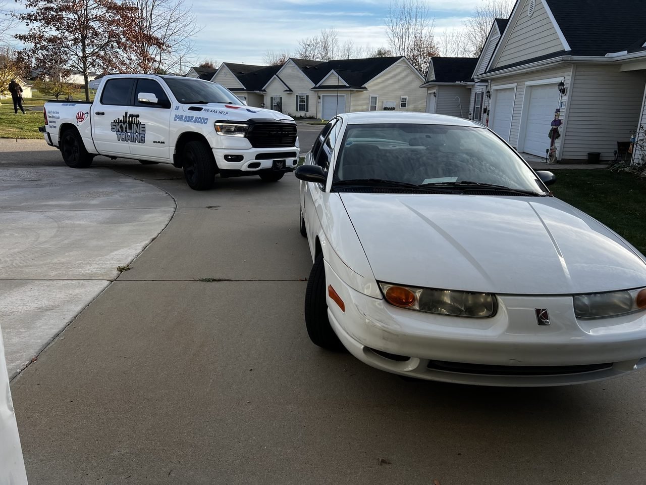 Skyline Towing roadside service truck on a call with a customer's car in a Metro Detroit driveway