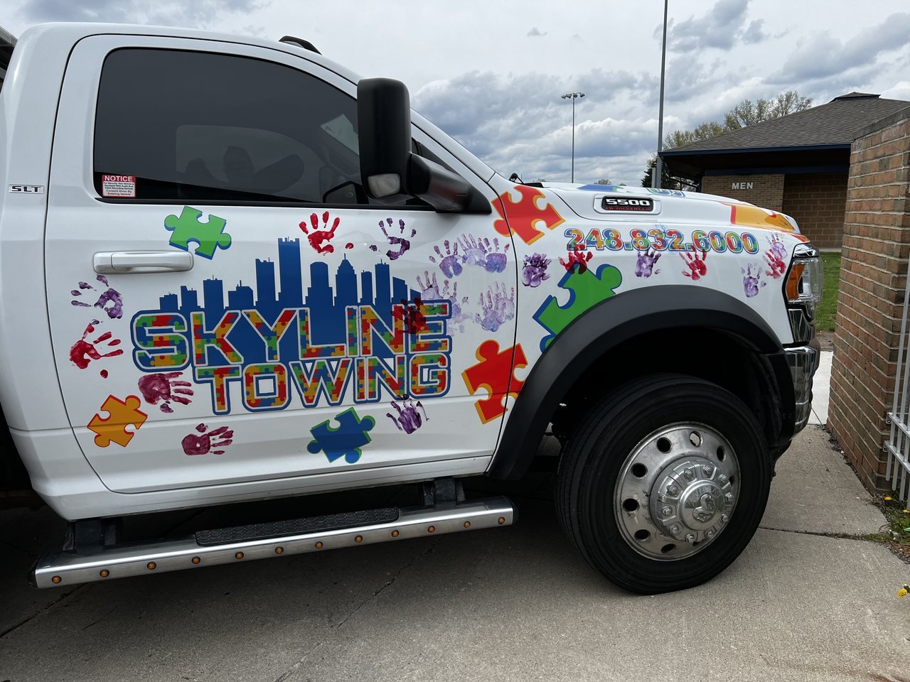 Skyline Towing truck decorated with puzzle pieces and handprints from an autism-awareness community event